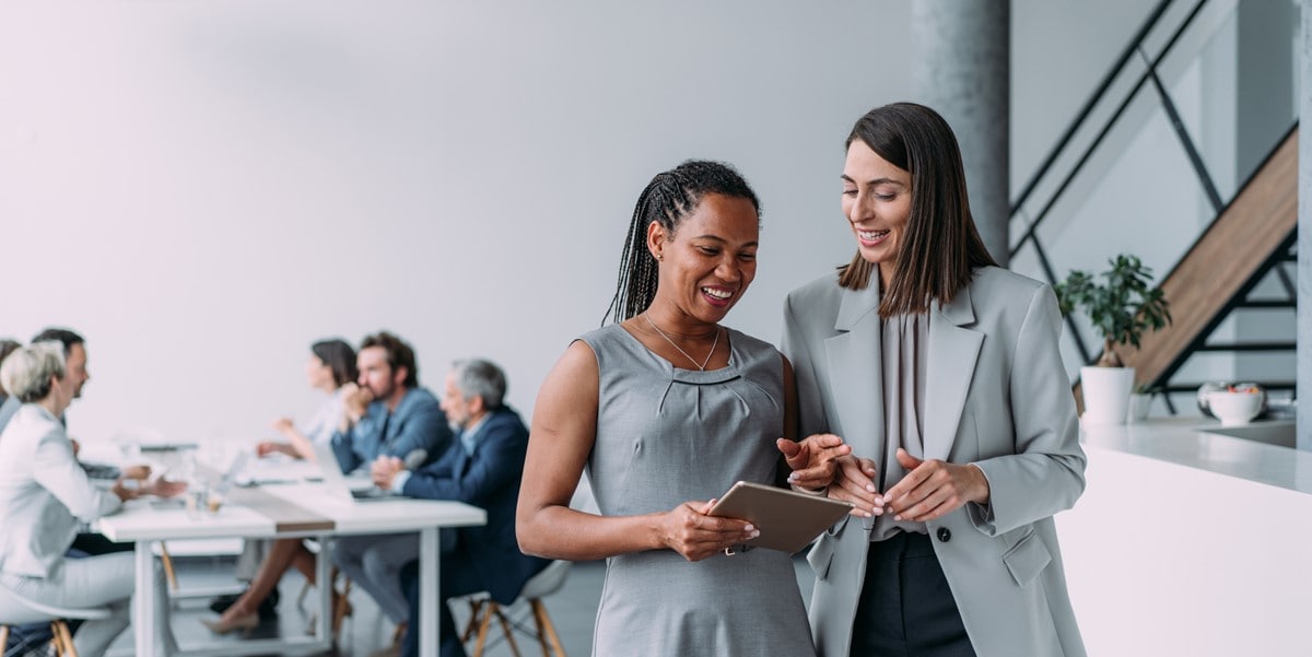 two professional women reviewing document in office