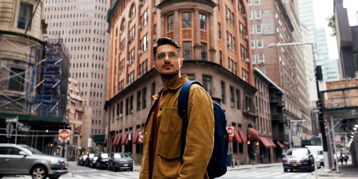 man standing in front of building, in a city